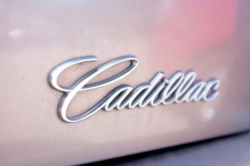 Close up of the Cadilac emblem on a pink car