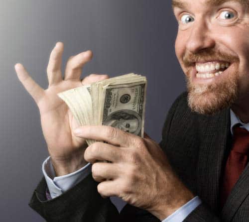 Delighted businessman counts his stack of money