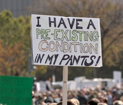 Pre existing condition sign at a rally